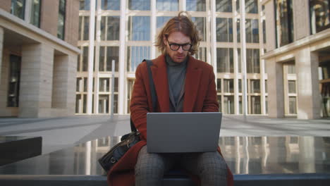 Elegant-Caucasian-Businessman-Working-on-Laptop-Outdoors